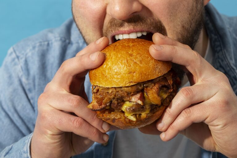 söömishäirega mees hamburgerit hammustamas