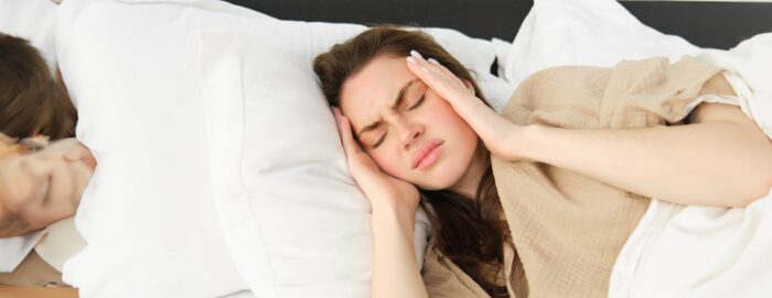naine lamab voodis ja hoiab kahe käega peast kinni, sest kannatab kroonilise valu käes